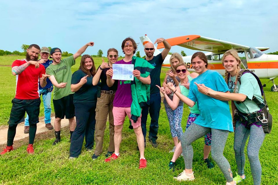 Licensed skydivers and friends celebrate a skydiving student earning his skydiving license at Texas Skydiving near Austin, TX