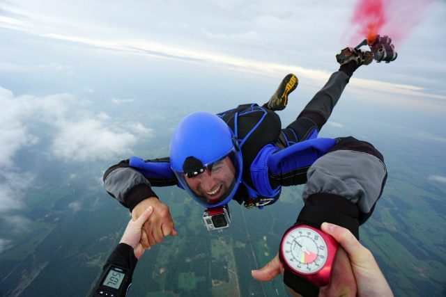 Licensed skydivers holding hands in freefall