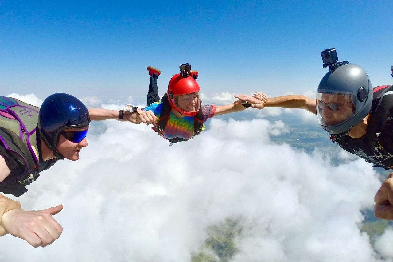 Licensed skydivers hold wrists during a formation skydive