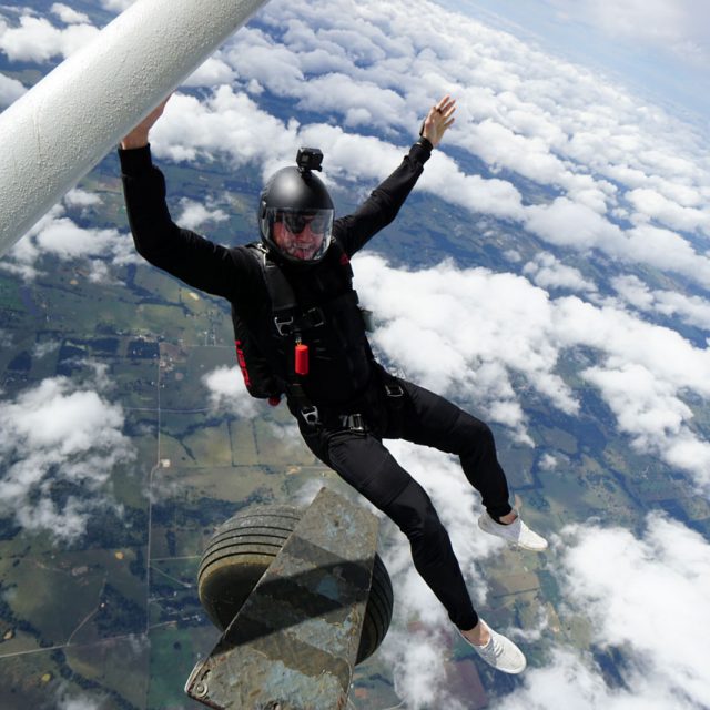 Licensed skydiving in black jumpsuit exiting a plane at Texas Skydiving