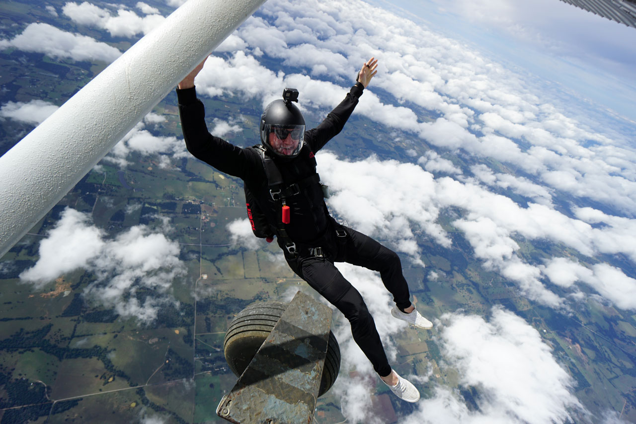 Licensed skydiving in black jumpsuit exiting a plane at Texas Skydiving