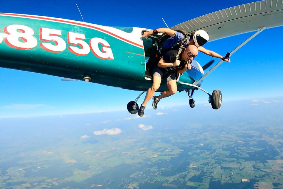 Male tandem student getting ready to exit an aircraft for a tandem skydive at Texas Skydiving near Austin