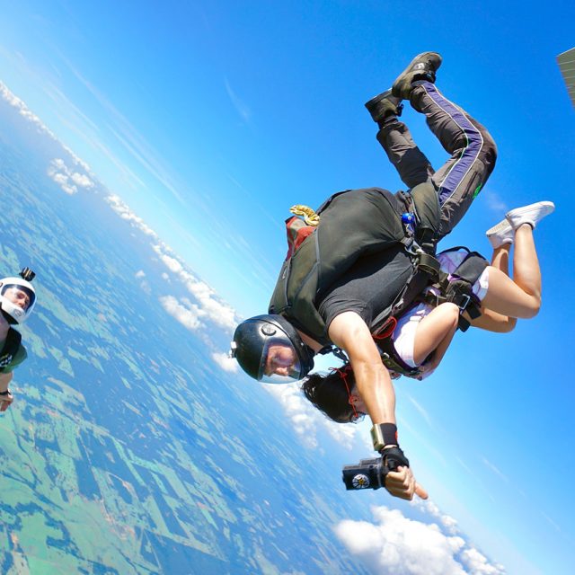 Outside camera flyer capturing a student tandem skydiving at Texas Skydiving near Austin, TX