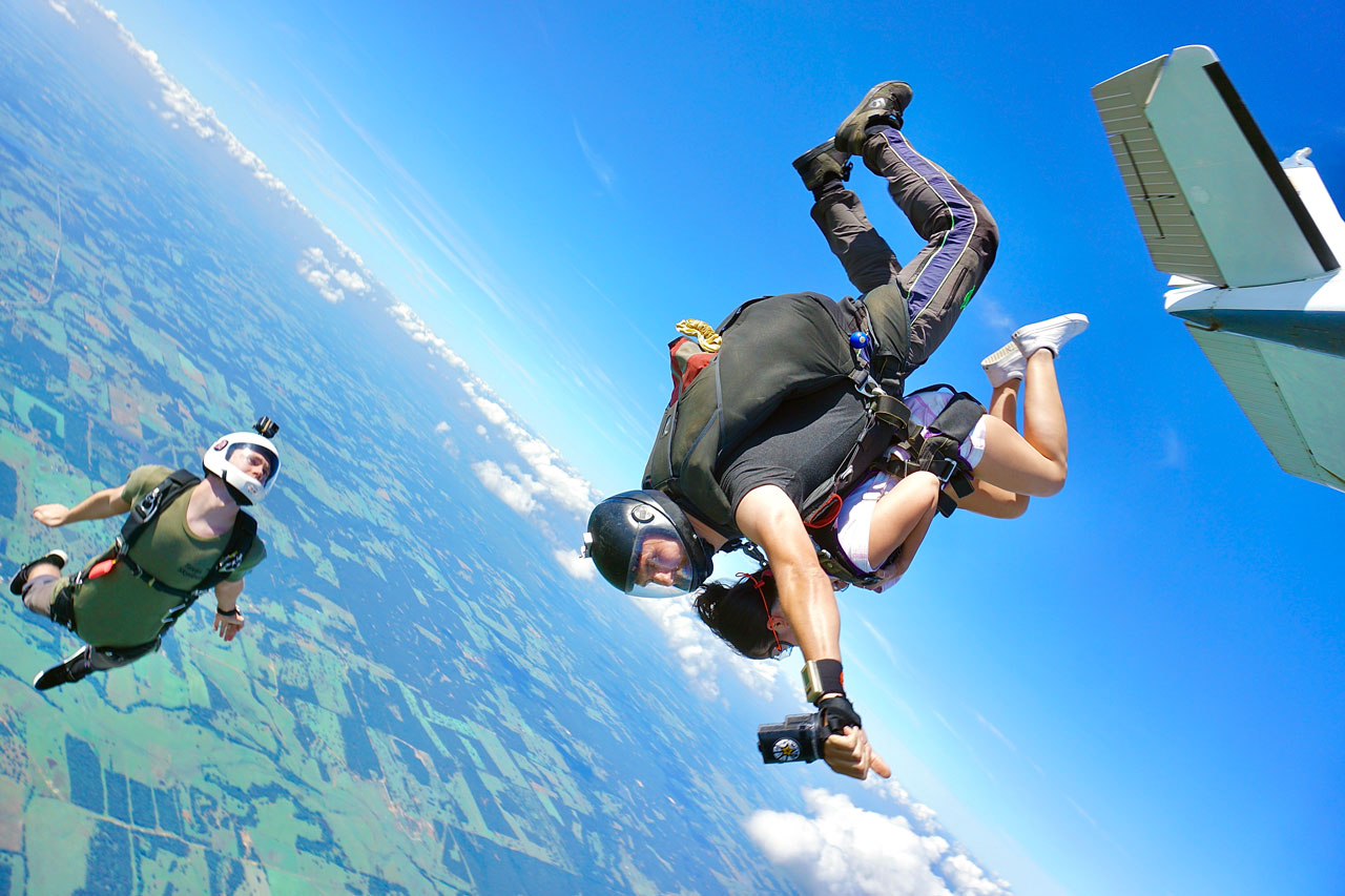 Outside camera flyer capturing a student tandem skydiving at Texas Skydiving near Austin, TX