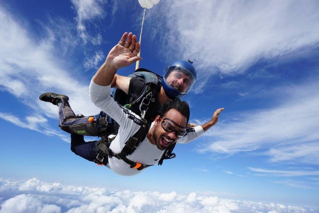 Man in white shirt in freefall during a tandem skydive at Texas Skydiving near Austin, TX