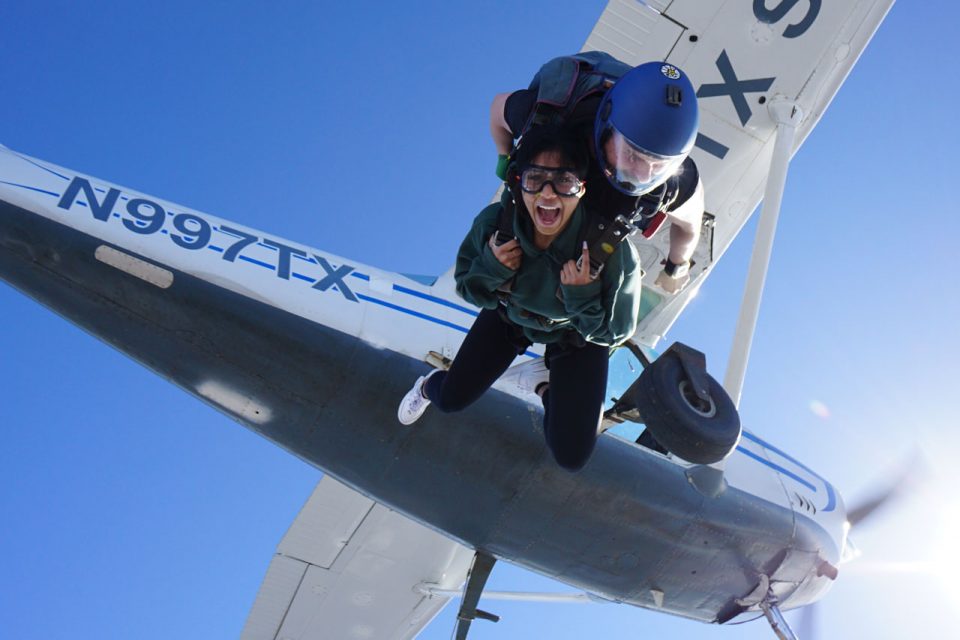 Tandem student exiting aircraft with instructor during a tandem skydive at Texas Skydiving near Austin, TX