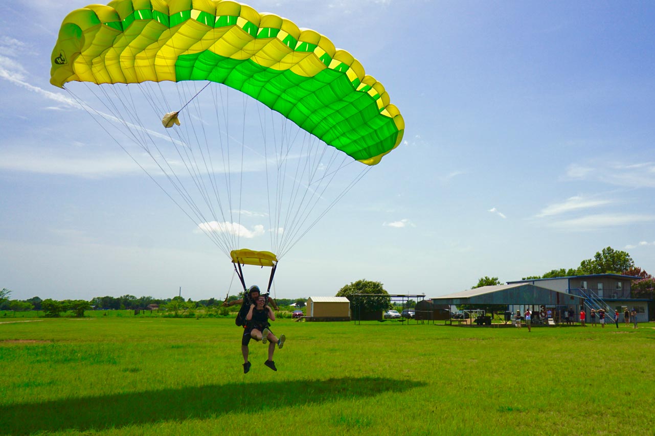 Tandem skydiving student landing in a green field after his first time skydiving at Texas Skydiving near Austin, TX