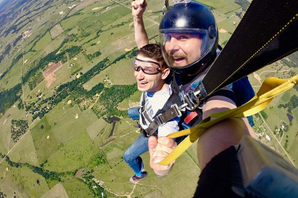 Male tandem skydiving student and instructor under canopy during a tandem skydive at Texas Skydiving near Austin, TX