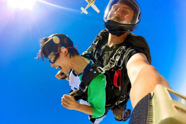 Tandem skydiving student and instructor in freefall with blue sky background at Texas Skydiving near Austin and College Station, TX