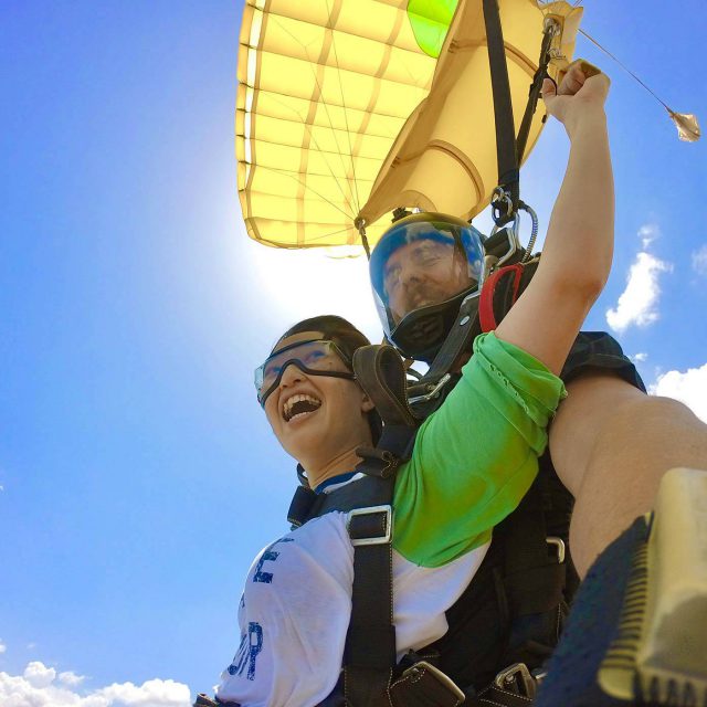 Tandem skydiving student smiles while under canopy during a tandem skydive at Texas Skydiving